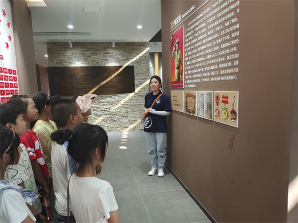 图为孩子们认真听大学生党员代表郝博文讲解壶梯山战役的英雄人物张富清.jpg